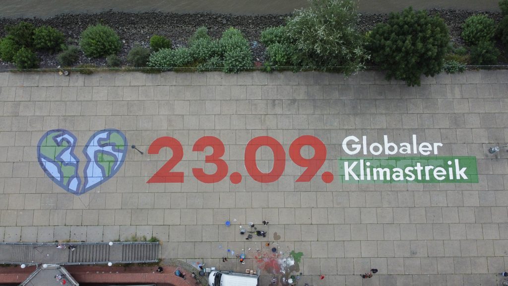 Schriftzug auf dem Hamburger Fischmarkt: 23.09. Globaler Klimastreik mit herzförmiger Erde, die auseinanderbricht